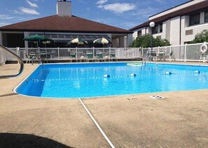 Una piscina al aire libre de temporada, sillones reclinables de piscina