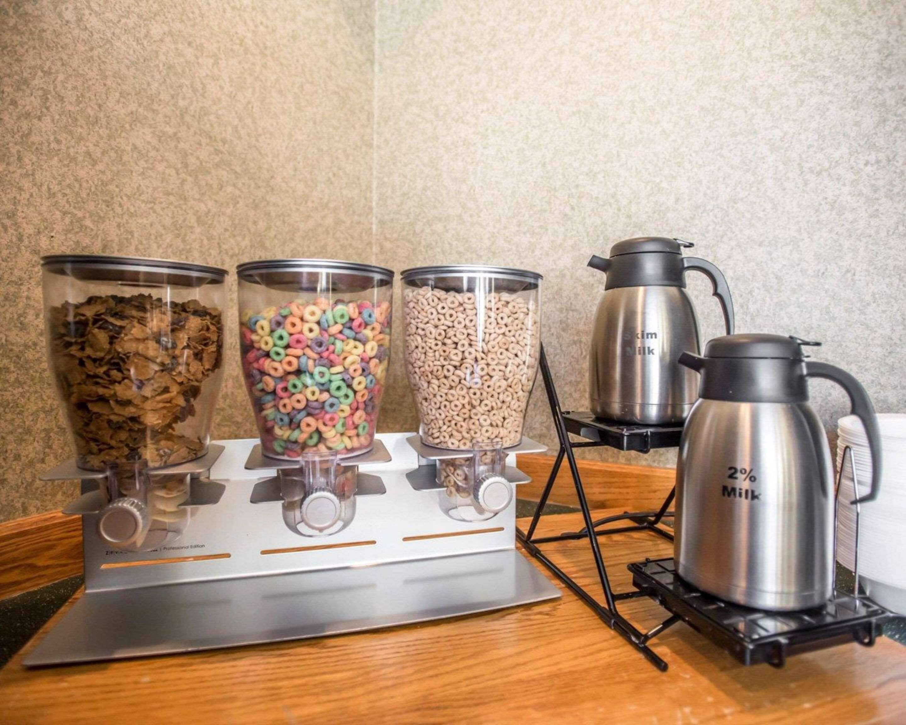 Una cocina con tres recipientes de vidrio sobre la estufa, una caldera de leche y una cafetera.