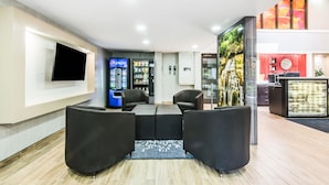 A lobby with a seating area, a vending machine, a phone, and a reception desk.
