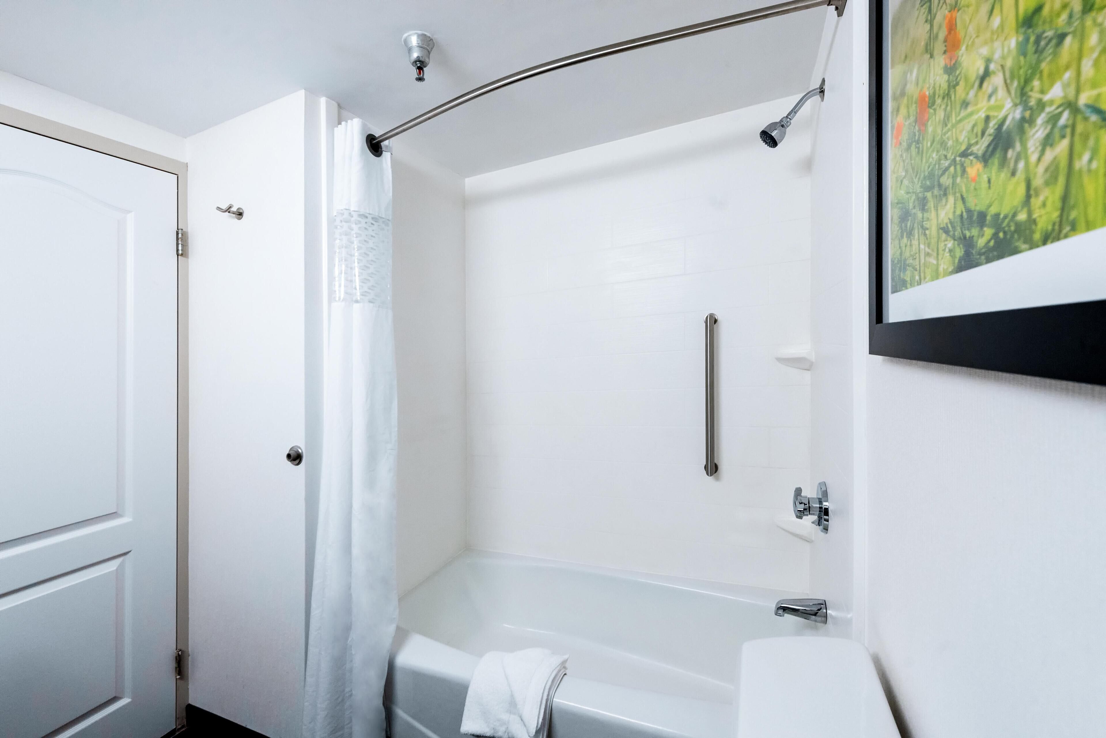 A bathroom with a bathtub, shower, and toilet.