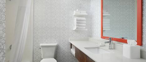 A modern bathroom with a toilet, a sink, and a mirror.