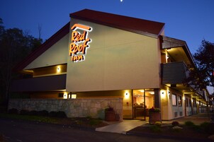 A building with a sign reading 'Red Roof Inn' and a stone facade.
