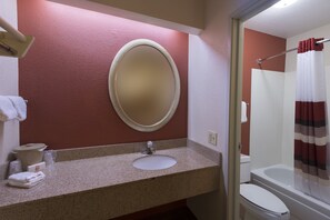 A bathroom with a round mirror, sink, and toilet. - Red Roof Inn St Clairsville - Wheeling West (St. Clairsville)