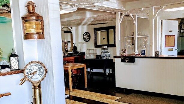 A hotel lobby with a wooden floor, a bar area, a clock, and a decorative lantern.