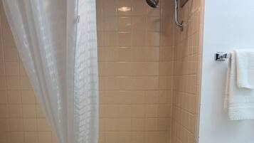 A bathroom with a bathtub, shower, and toilet.