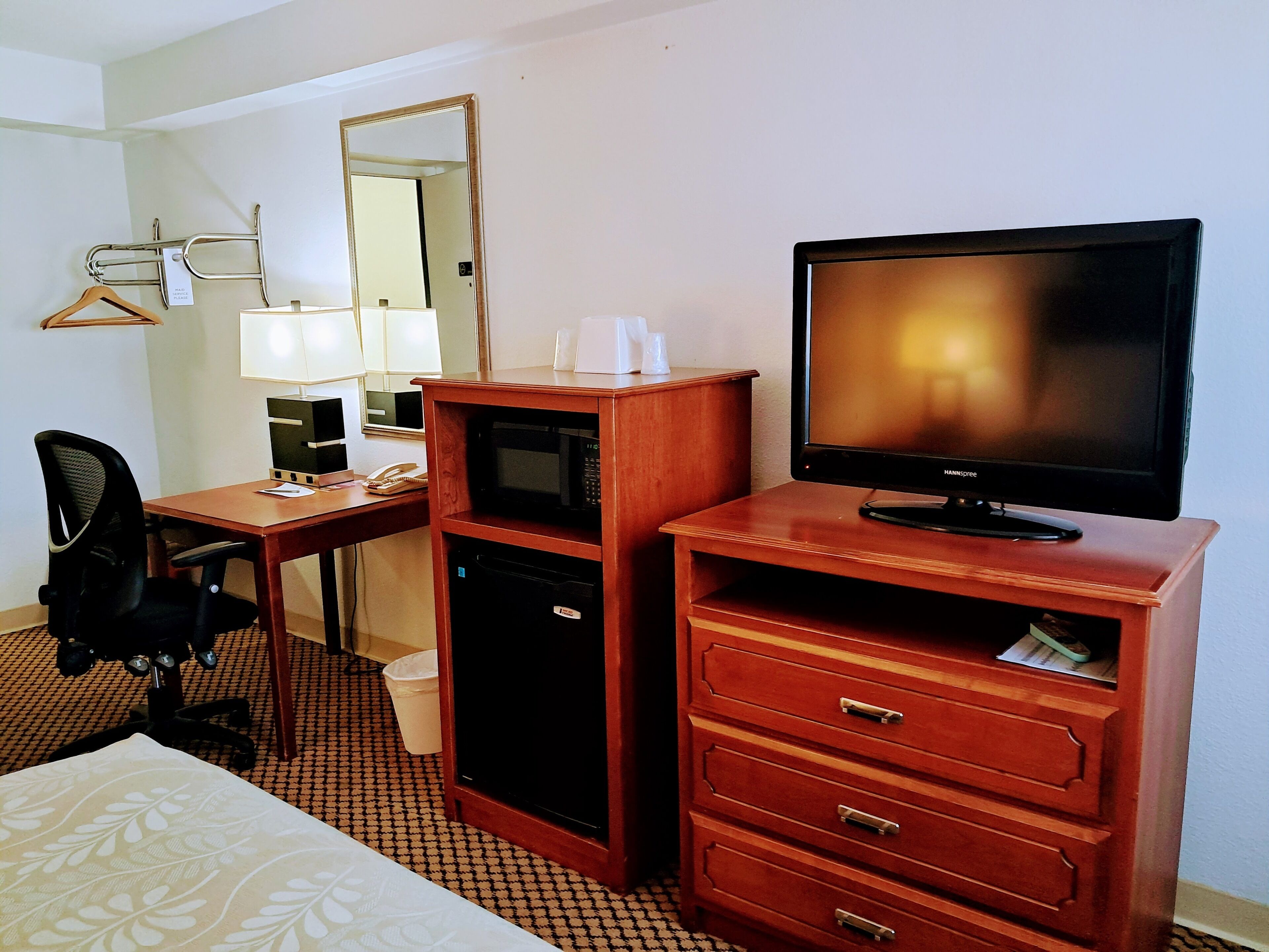 Une chambre d’hôtel équipée d’un bureau, d’une chaise, d’une télévision et d’un mini-bar.