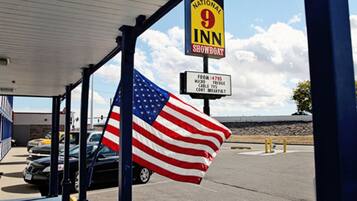 A National 9 Inn with an American flag, a sign indicating amenities like a mini-fridge, cable TV, and breakfast.