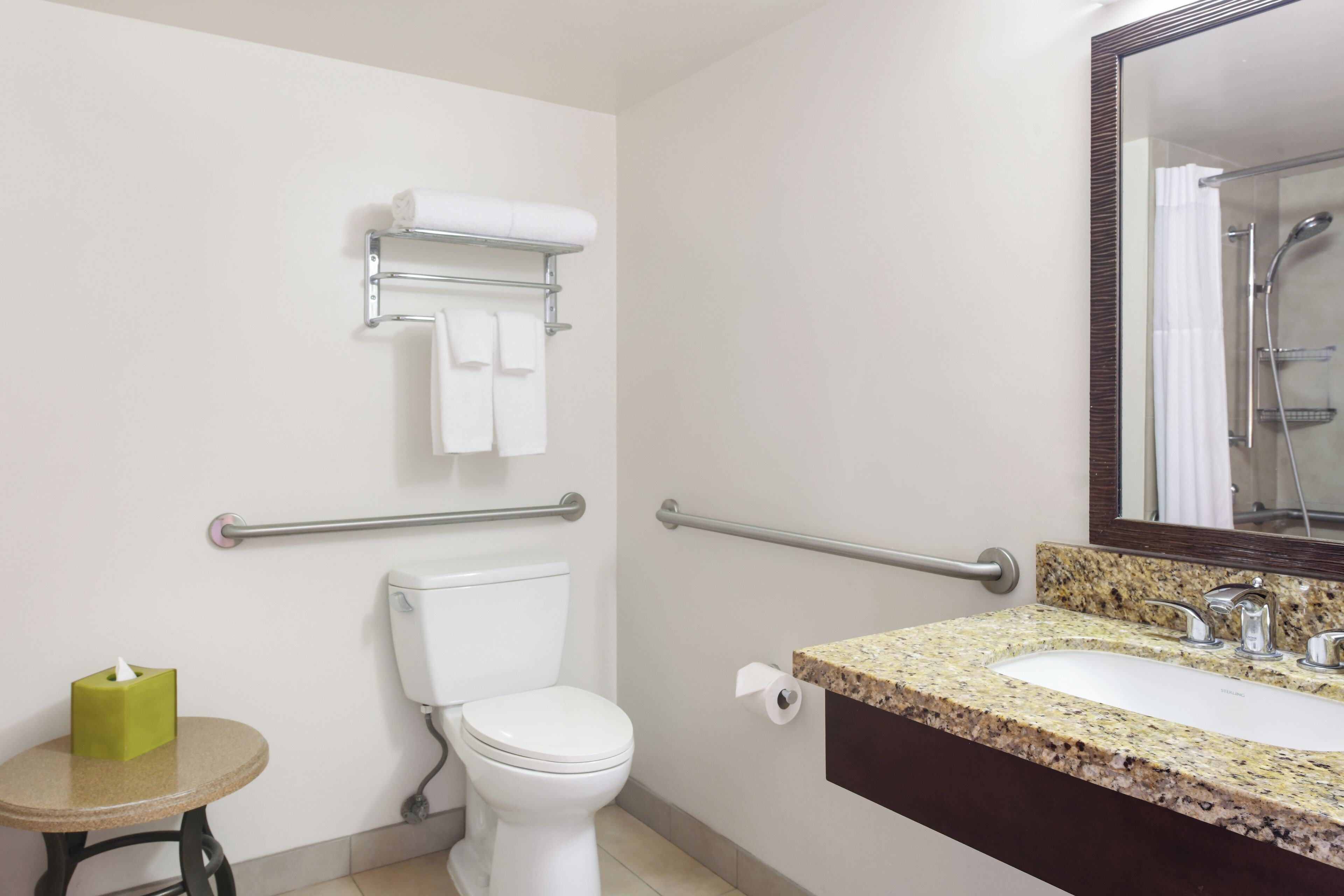 Ein Badezimmer mit Toilette, Waschbecken, Spiegel und Handtuchhalter.