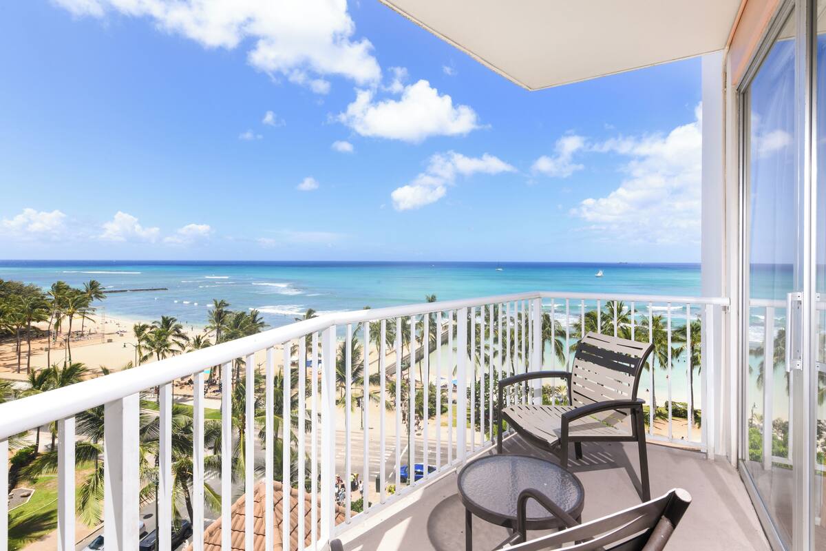 Un balcon avec vue sur une plage et l’océan.