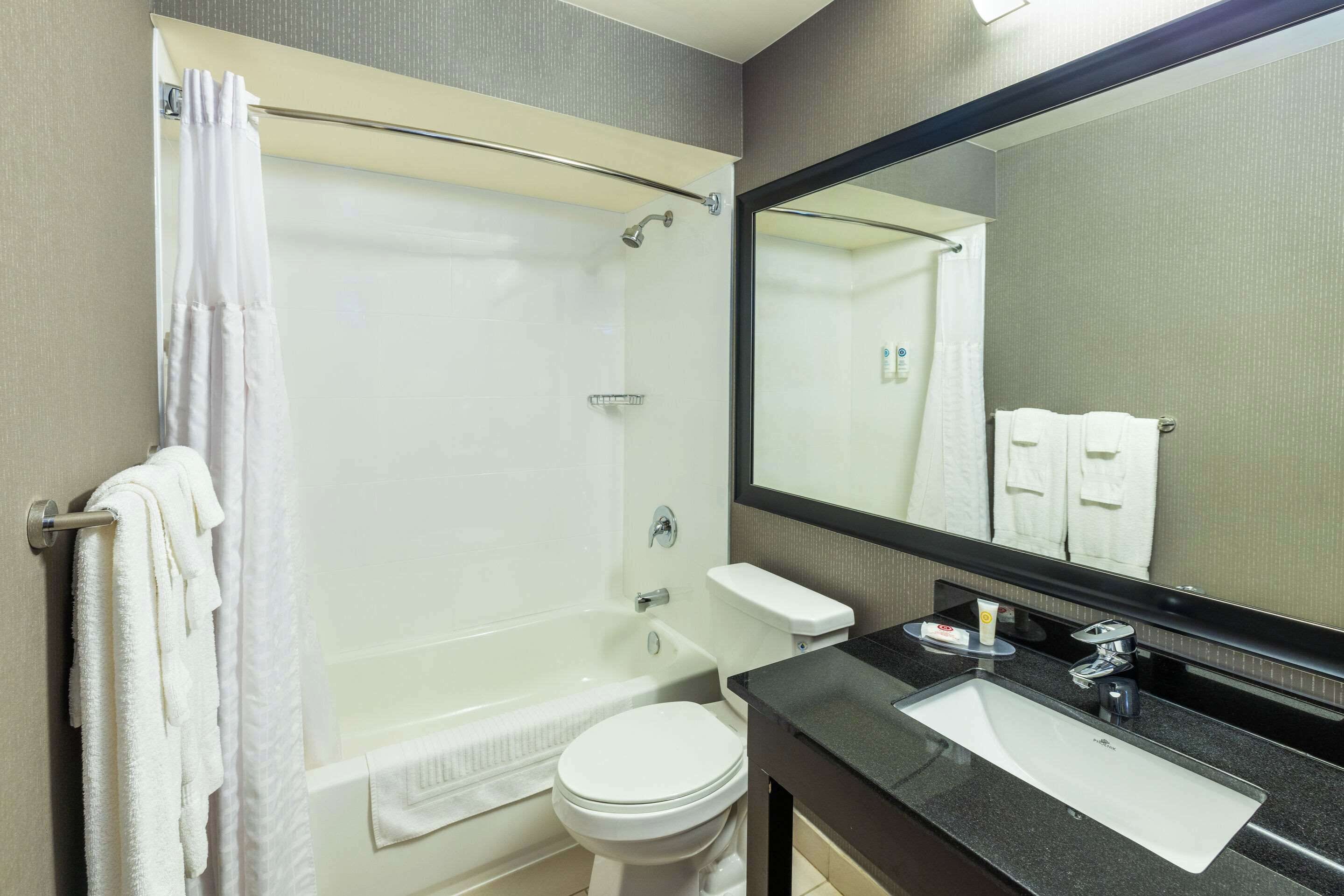 A modern bathroom with a bathtub, toilet, and sink.
