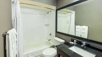 A modern bathroom with a bathtub, toilet, and sink.