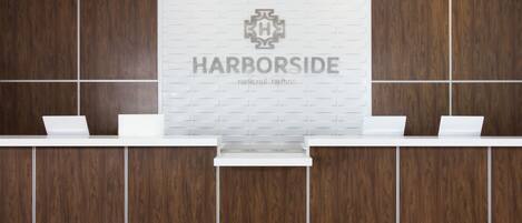 A reception desk with a white countertop and a logo above it.