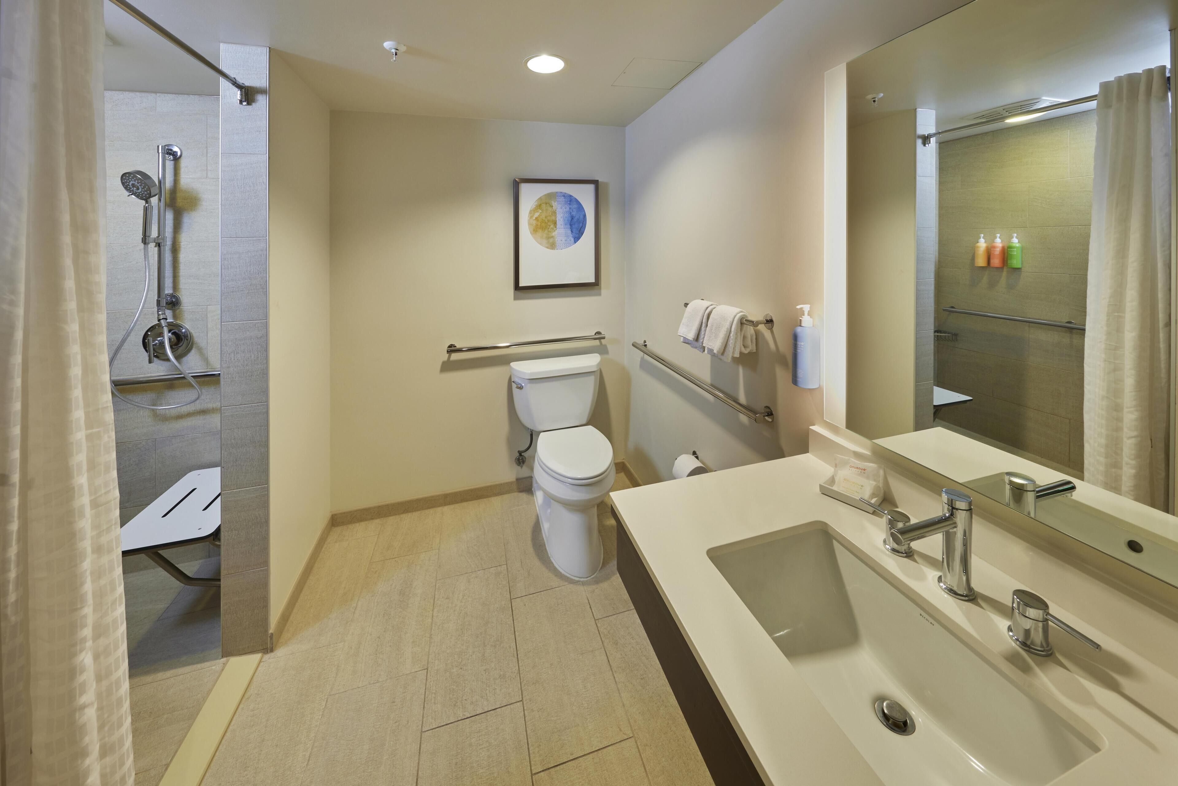 Un baño moderno con ducha, inodoro y lavamanos.