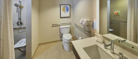 A modern bathroom with a shower, toilet, and sink.