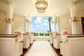 A wedding aisle with floral decorations, a chandelier, and a view of the beach. - Hilton Hawaiian Village Waikiki Beach Resort (Honolulu)