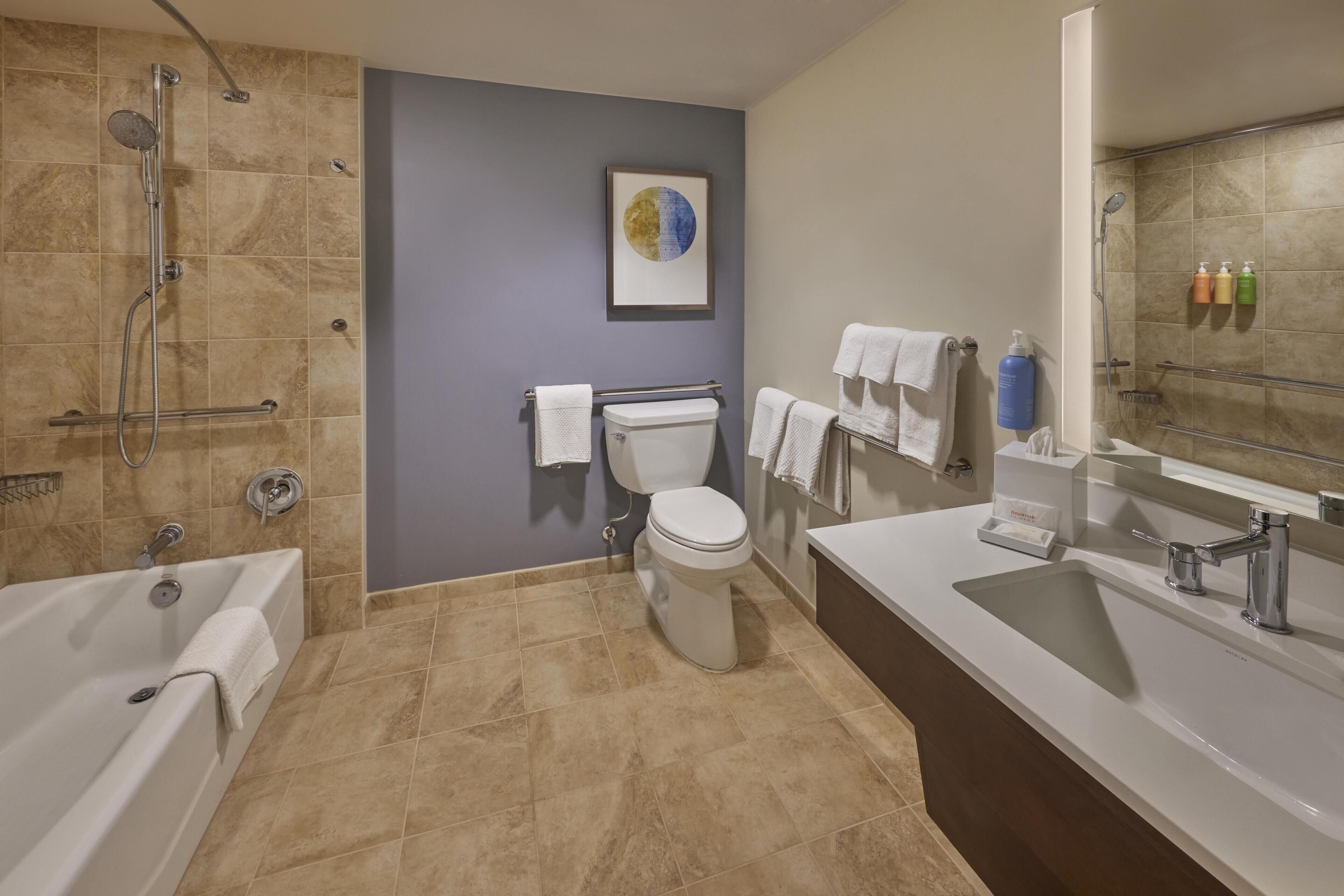 Ein modernes Badezimmer mit Badewanne, Toilette und Dusche.