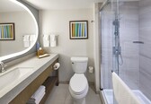 A modern bathroom with a toilet, sink, and shower.