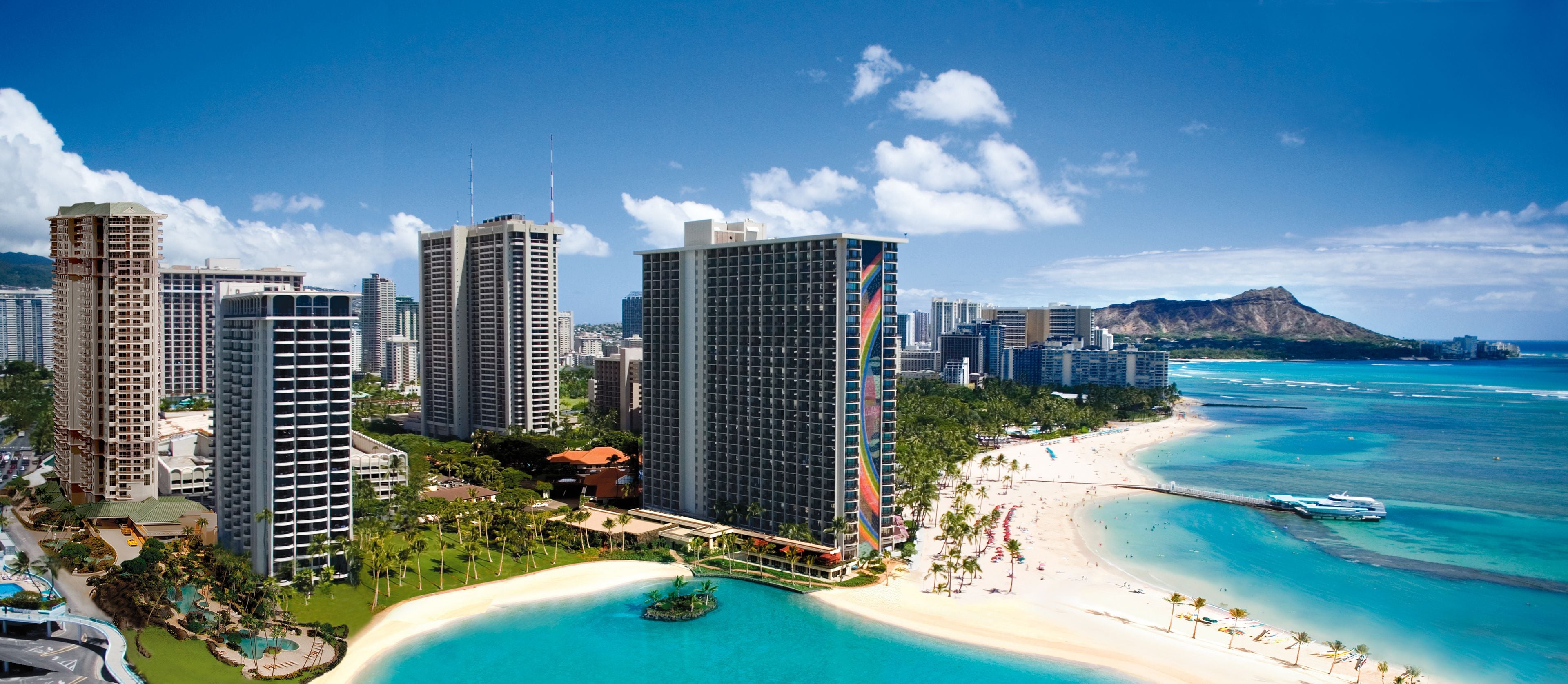 Un paisaje costero con edificios altos, una playa y un cielo azul despejado.