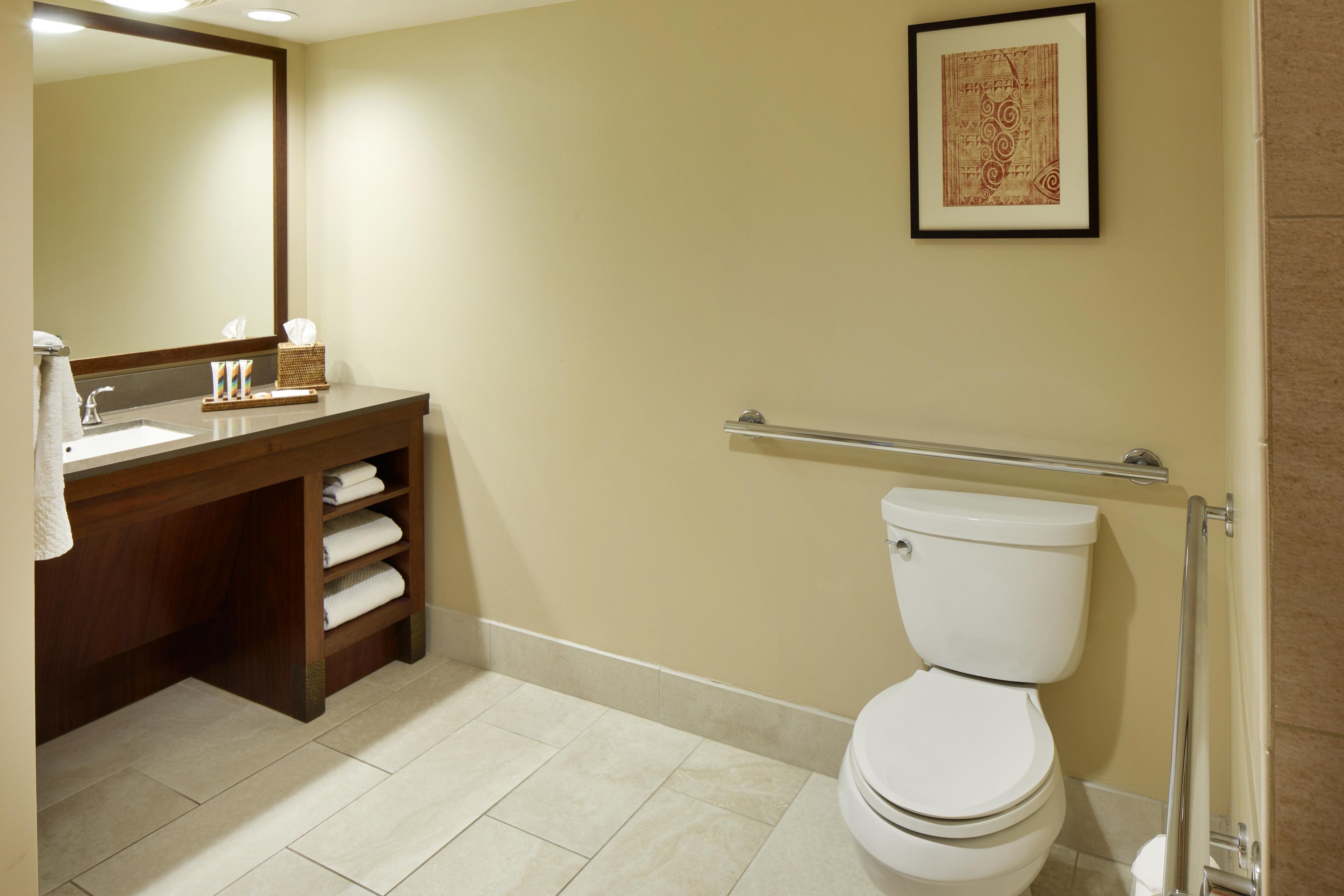 A bathroom with a toilet, sink, and mirror.