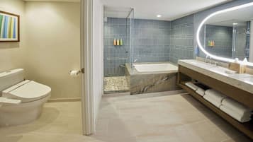 A modern bathroom with a toilet, a bathtub, and a vanity with a mirror.