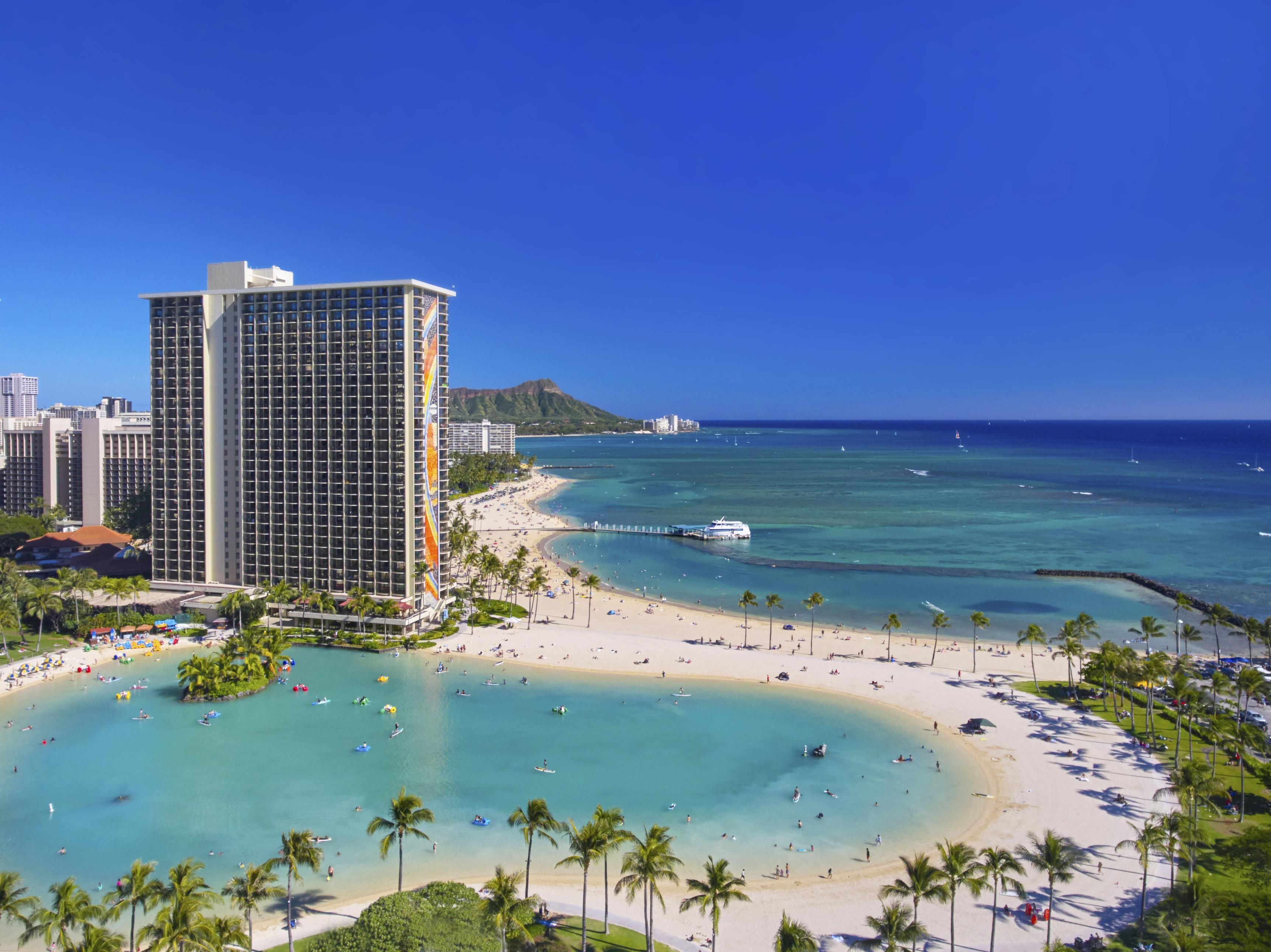 A beachfront hotel with a pool, beach, and ocean view.