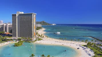 A beachfront hotel with a pool, beach, and ocean view.