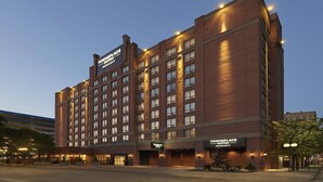 A multi-story hotel with a brick facade, multiple entry points, and illuminated signage.