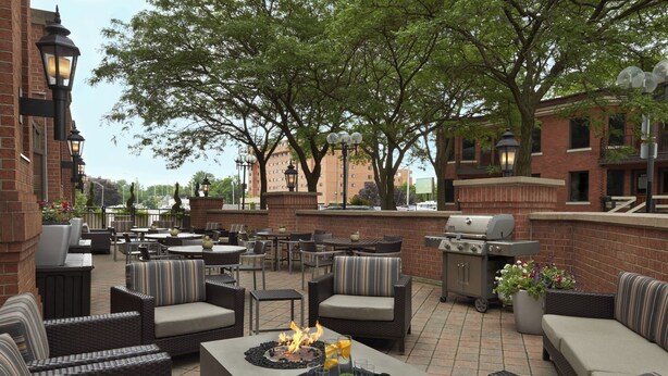 An outdoor patio area with seating, a grill, and a fire feature.