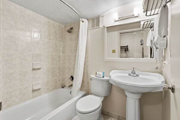 Un baño con bañera, inodoro y lavamanos.