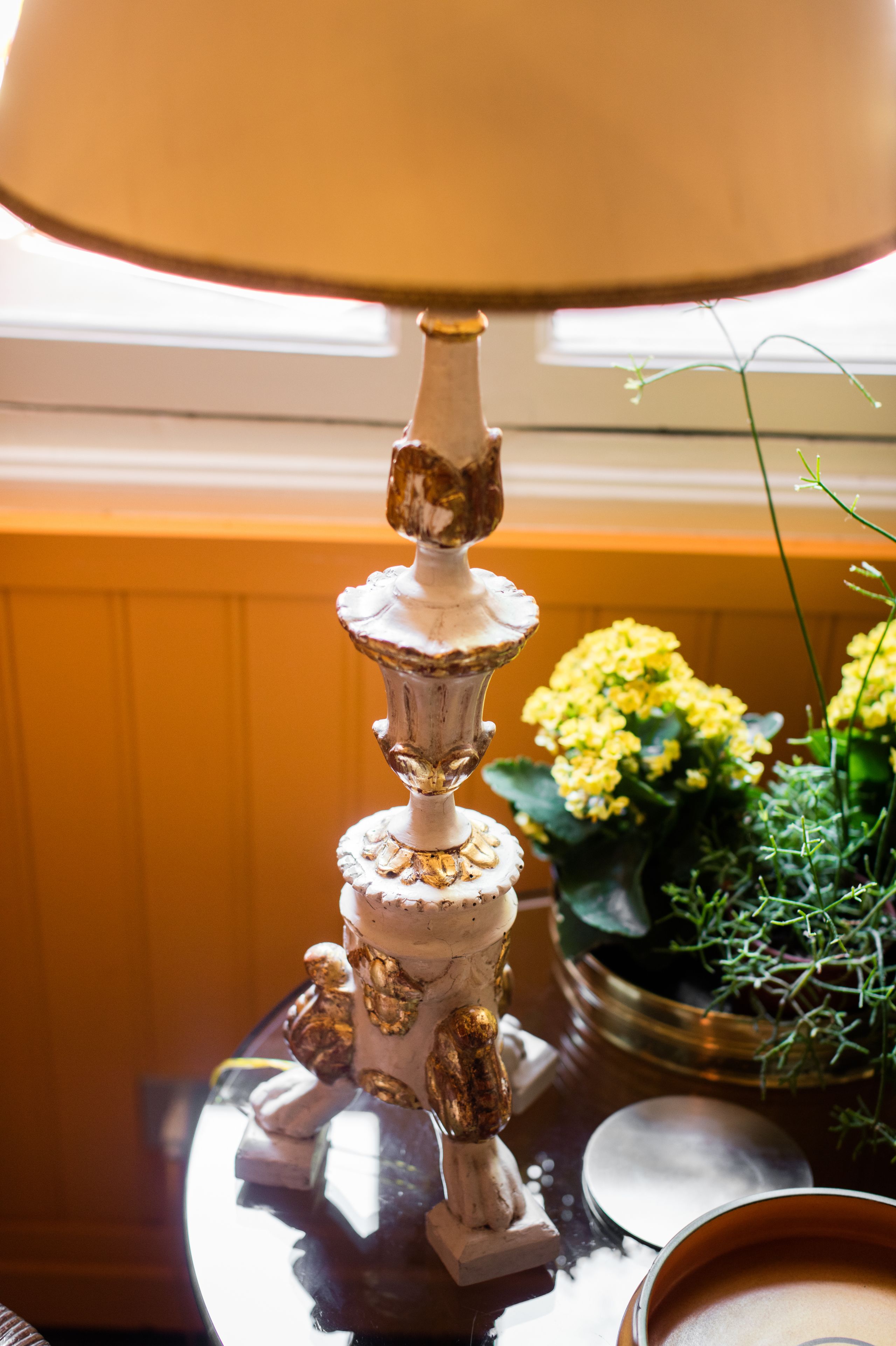 A decorative fountain with multiple tiers, a lamp, and a potted plant with yellow flowers.
