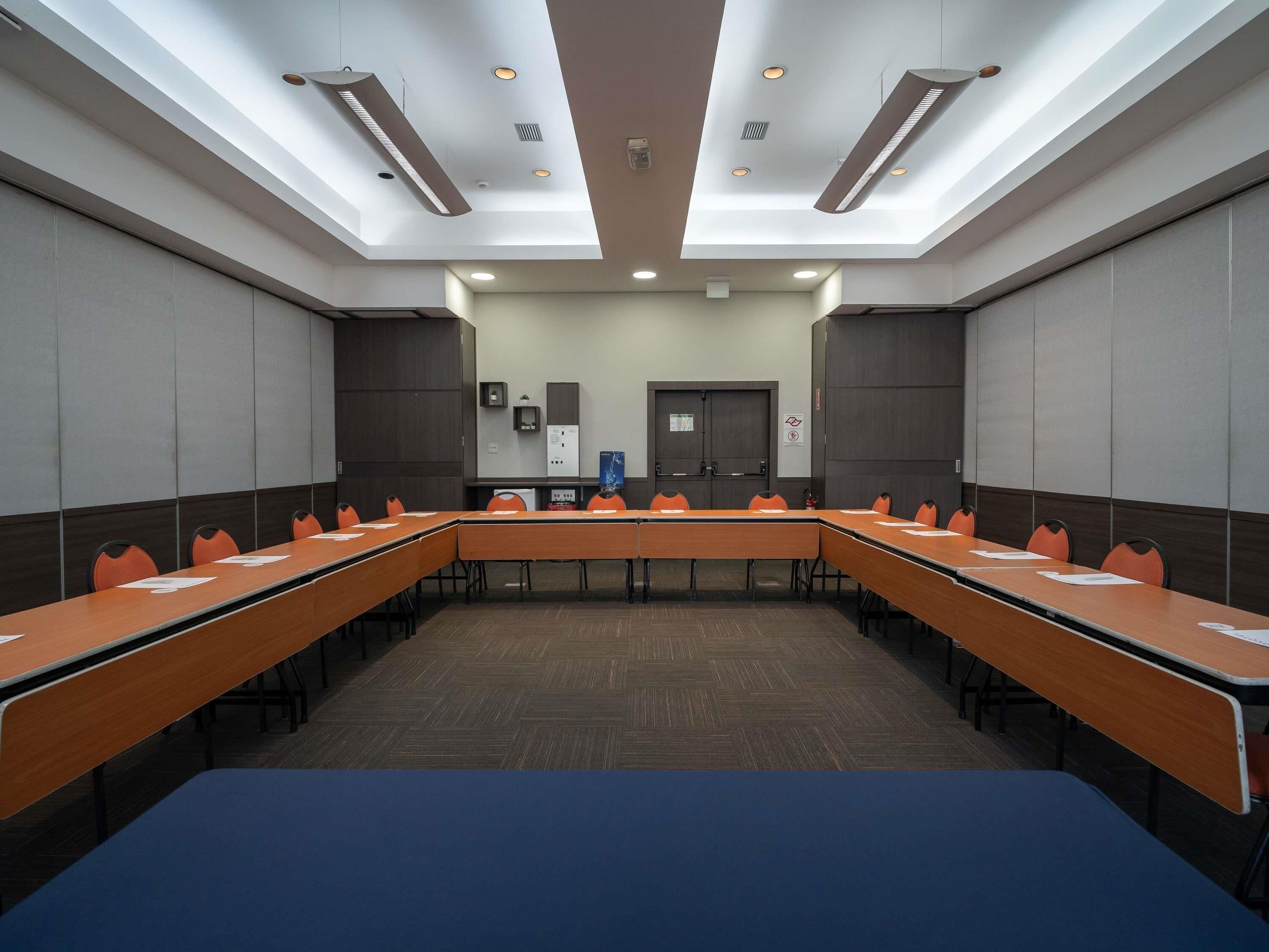 A conference room with a long table, chairs, and a door.