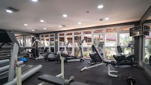 Un gimnasio con cintas de correr, elípticas y equipos de levantamiento de pesas.