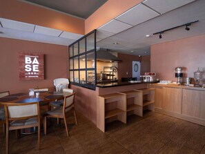 Ein Restaurantinneres mit Theke, Sitzbereich und einer sichtbaren Küche im Hintergrund.