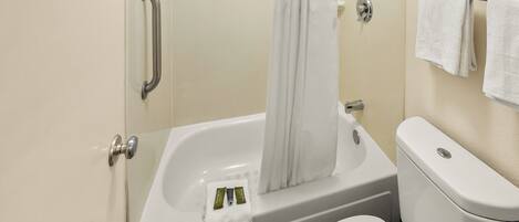 Une salle de bain standard équipée d'une baignoire, de toilettes et d'un porte-serviettes.