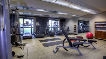 A gym with treadmills, exercise balls, and weight machines.