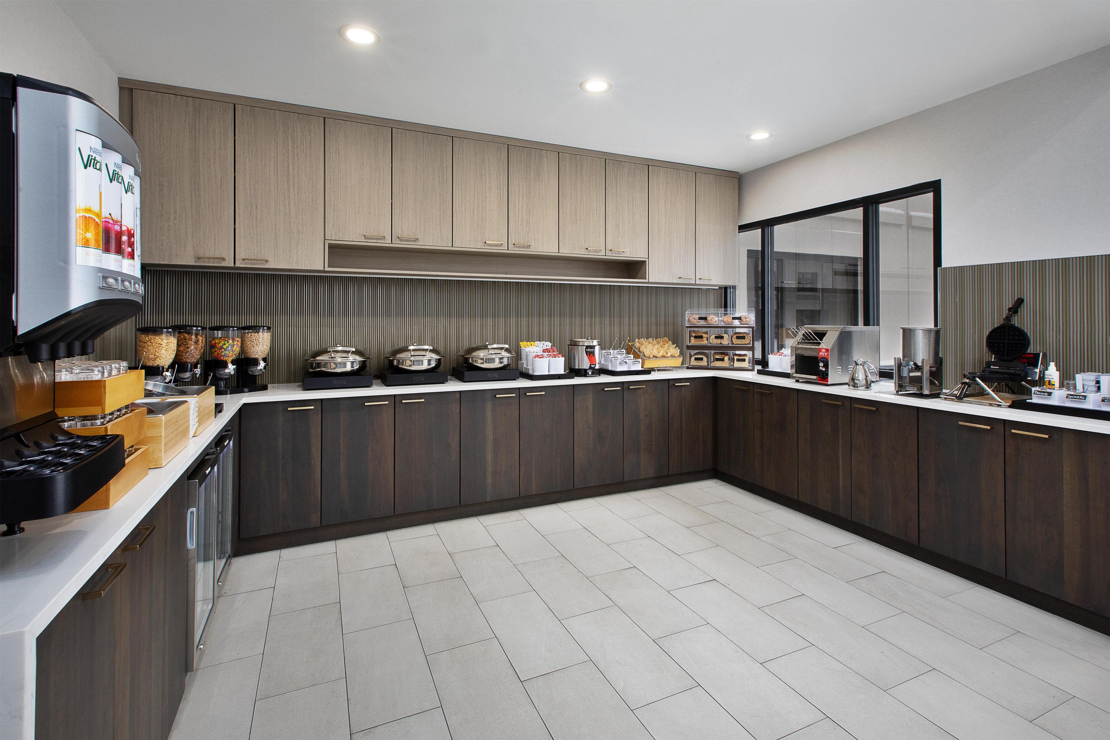 A modern kitchen with dark wood cabinets, a built-in stove, and various appliances.