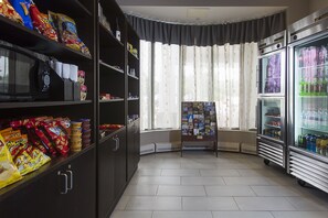 A snack bar with shelves stocked with chips, snacks, and bottled water. - DoubleTree by Hilton Detroit Novi (Novi)
