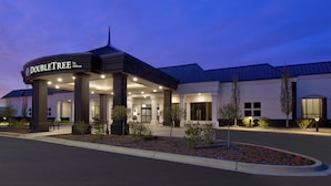 L’entrée d’un hôtel, dotée d’un espace abrité, de colonnes et d’une enseigne indiquant « DOUBLETREE by Hilton ».