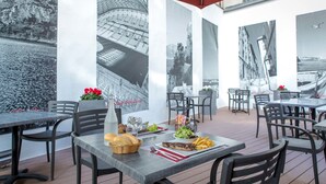 An outdoor dining area with tables, chairs, and umbrellas. - ibis Marseille Timone (Marseille)