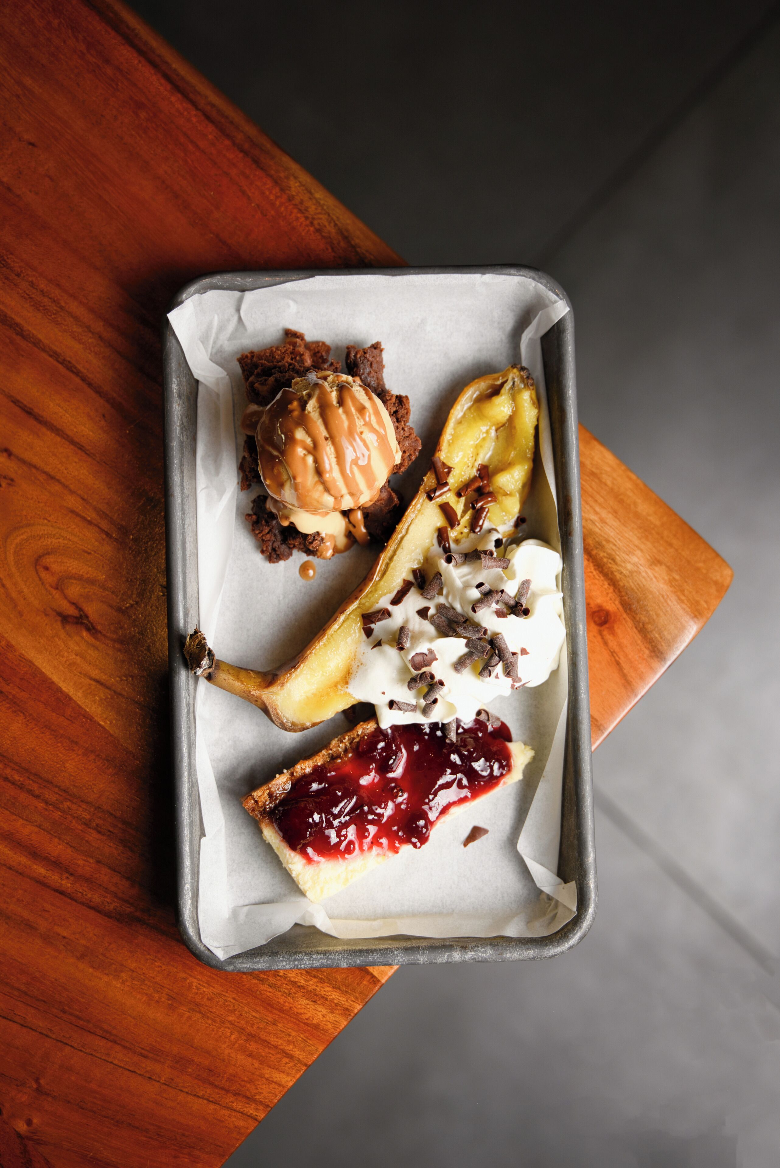 A dessert tray with various sweets on parchment paper.