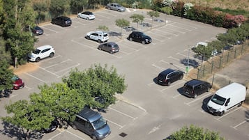 Ein Luftbild eines Parkplatzes mit verschiedenen Autos und einem weißen Lieferwagen.