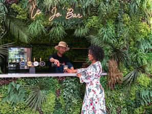 Un bar con un letrero de neón que dice "Ve Jo Bar" y una variedad de grifos de cerveza.
