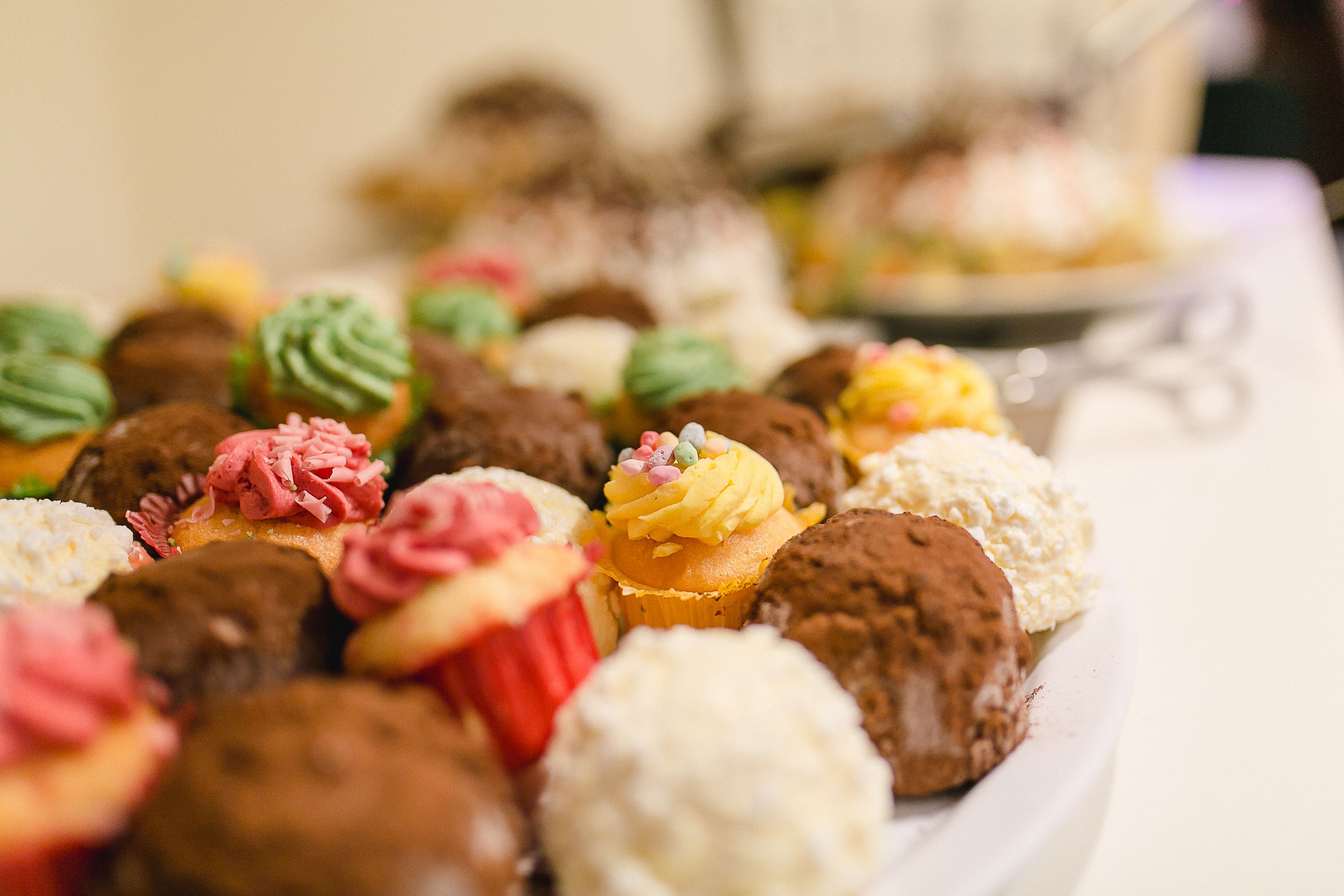 A variety of cupcakes and desserts on a white plate.