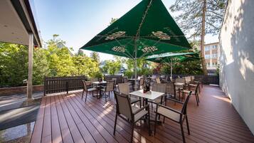 Relax on the outdoor patio surrounded by lush trees and enjoy meals at one of the several tables and chairs.