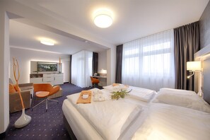 Una habitación de hotel con dos camas, un escritorio, una silla y un televisor.