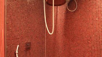 A shower with a wooden bucket and a hose.