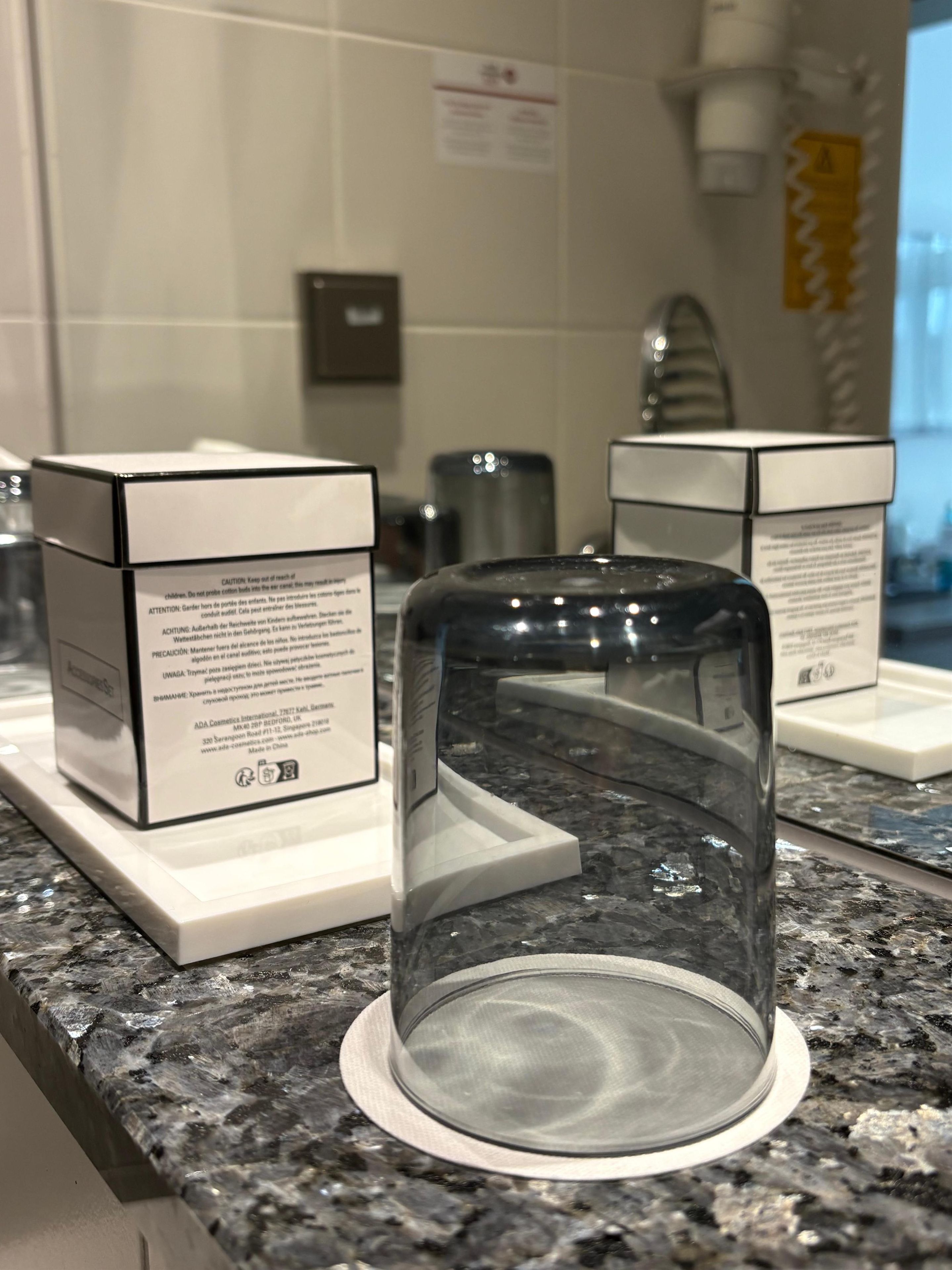 Una encimera de cocina con una cafetera, un dispensador de agua y dos cajas con instrucciones de seguridad.