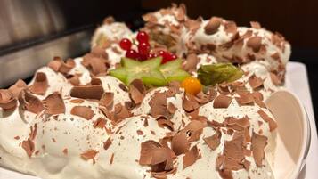Ein Dessert auf einem weißen Teller mit Schokoladenraspeln und roten Beeren.