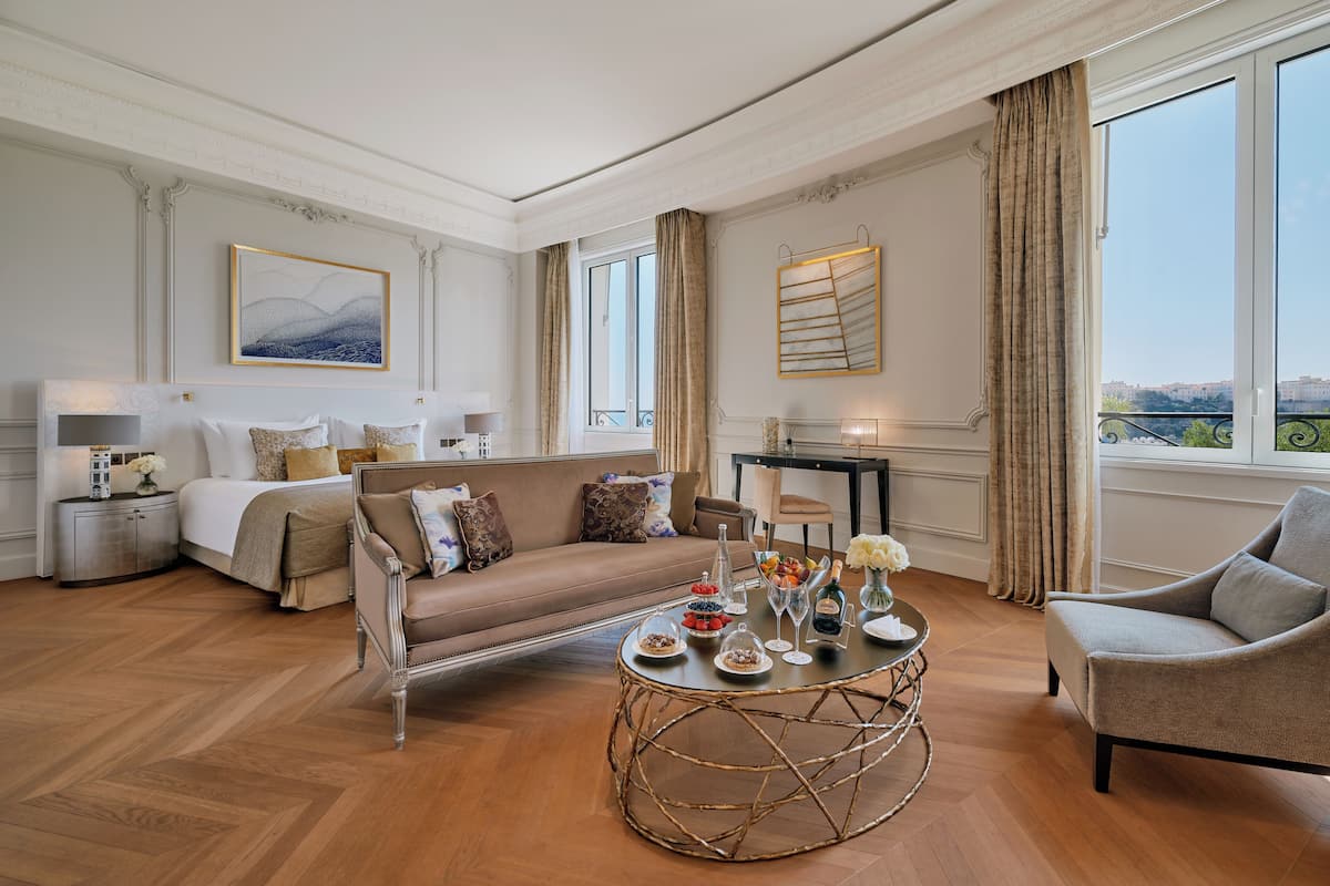 A spacious living room with a sofa, armchairs, a coffee table, and a dining table.