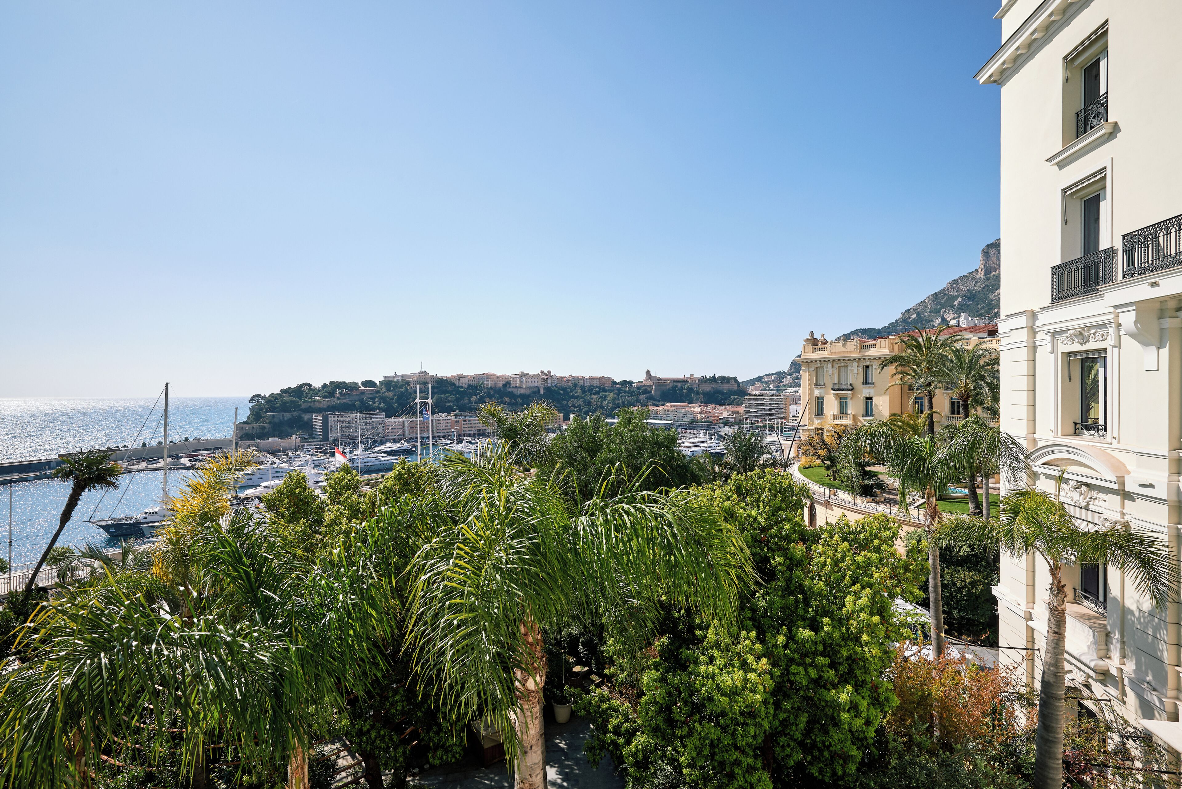 A coastal cityscape with buildings, a marina, and a clear sky.
